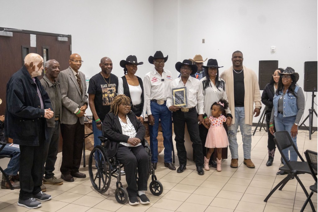 Families gathered with an award plaque at the scholarship banquet